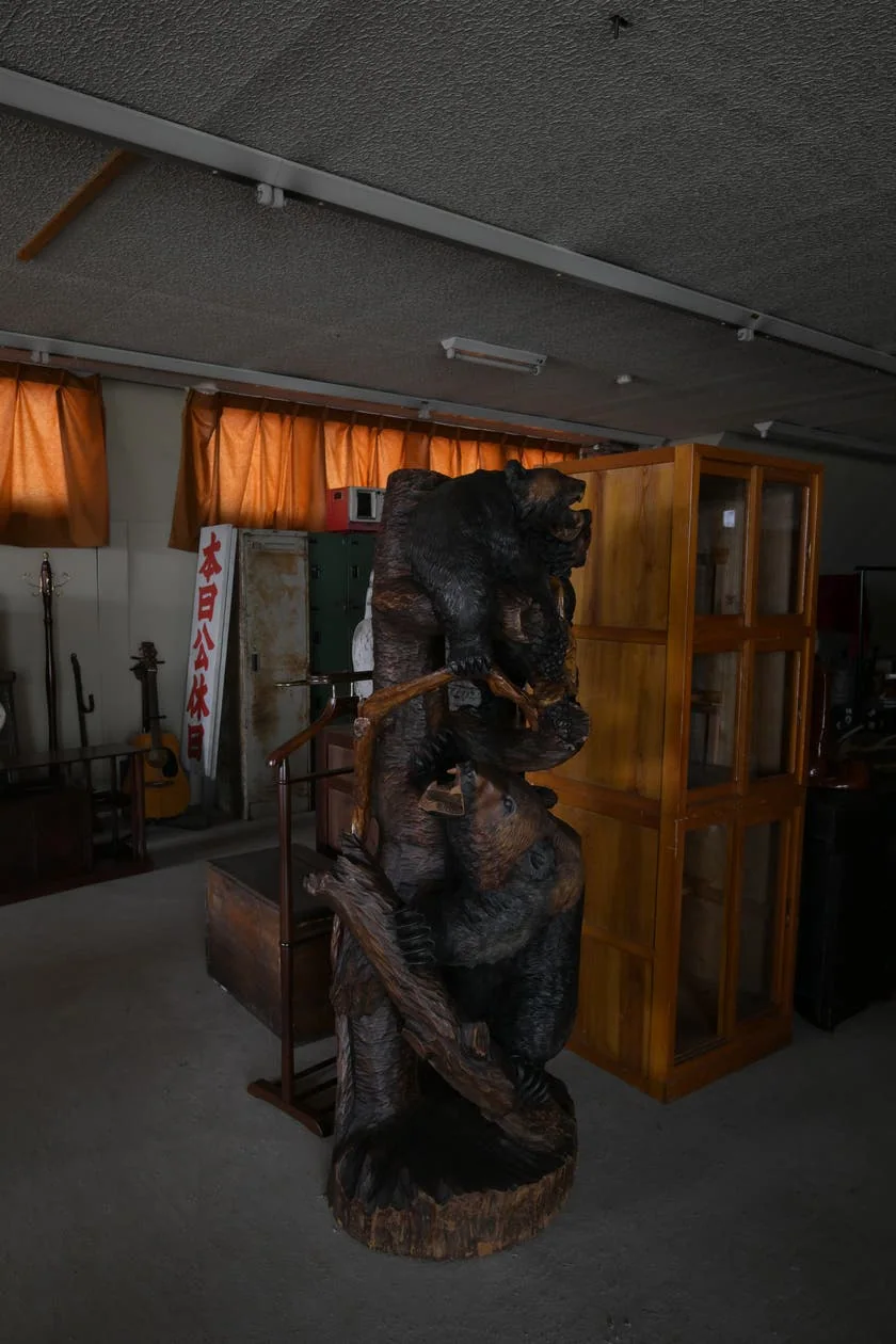木彫品と家具が並ぶ倉庫内の区画
